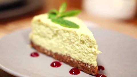 Small slice of tasty mint cheesecake on white plate in cozy cafe in detailed Stock Footage 105894711