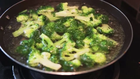 Small slices of green broccoli into a boiling water in a pan at the kitchen. Stock Footage 134939257