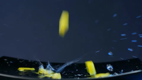 Small slices of yellow bell pepper fall on black plate 스톡 동영상 147378976