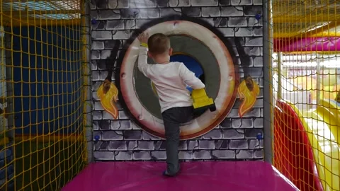 A small smart boy with a yellow bulldozer goes into the tunnel in the playroom Stock Footage 220734525