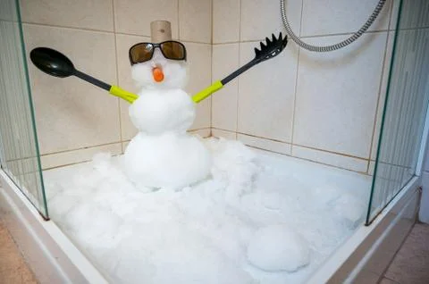 Small snowman built inside a shower with cutlery for hands. Stock Photos