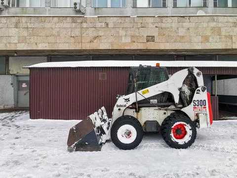 A small snowplow Bobcat backhoe loader. Stock Photos