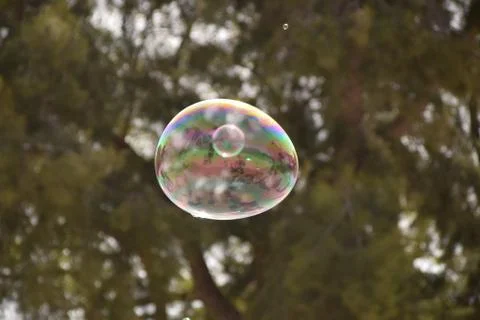 Small soap bubble inside big soap bubble Stock Photos