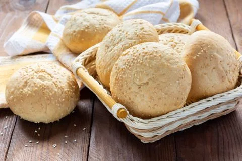 Small soft rolls with a crispy crust sprinkled with sesame seeds in a basket Stock Photos