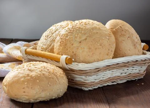 Small soft rolls with a crispy crust sprinkled with sesame seeds in a basket Stock Photos