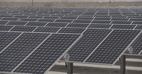 Small Solar farm in Desert Pan Static plus Tilt Down from Mountains Stock Footage 89941517