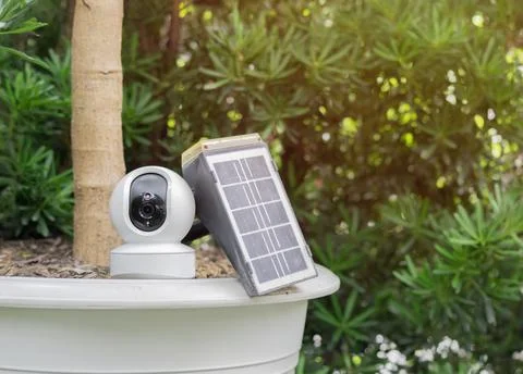 A small solar panel with CCTV camera install placed on the big white pot in.. Stock Photos