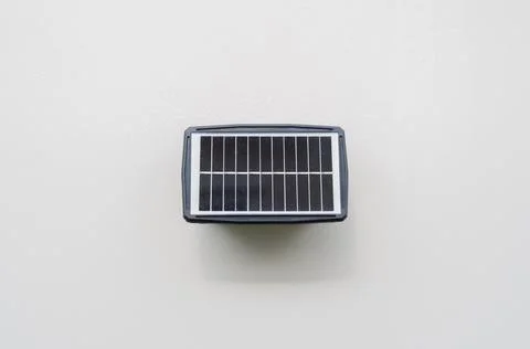 Small solar panel installed on wall at home for use lighting in night time. Stock Photos
