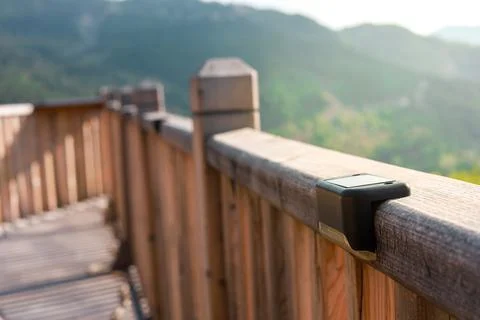 Small solar powered led light with motion sensor on wooden terrace Stock Photos