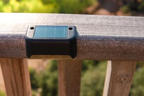Small solar powered led light with motion sensor on wooden terrace Foto stock