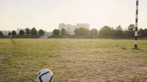 Small son kicks out the ball, laughs and fools while playing soccer with dad Video stock 111432275