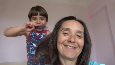 Small son skilfully combs his mother Stock Footage 108525073