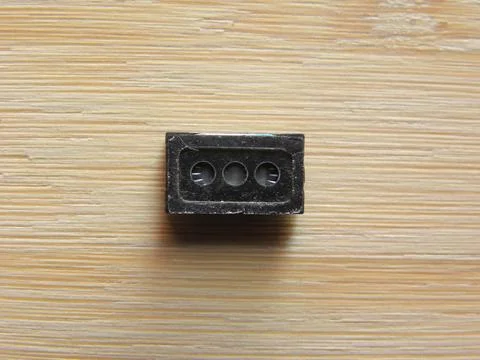 Small speaker micro component of smartphone kept on wooden table Stock Photos