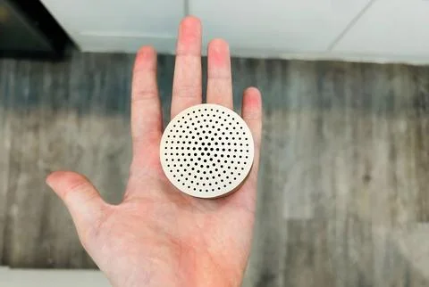 A small speaker in a person's hand. 스톡 사진