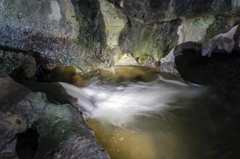 Small spring inside the cave deep inside the forest. Stock Photos