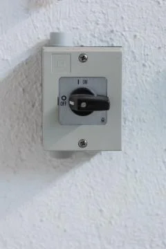 Small square electric switch box with on off markings set on a wall close up  Fotos de archivo