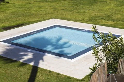 Small square pool with shadow of a palm tree on the island of Tenerife in Spain Stock Photos