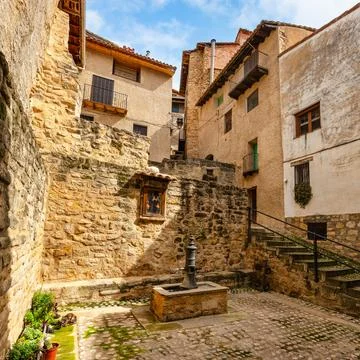 Small square surrounded by a stone house and fresh water fountain in the village Stock Photos