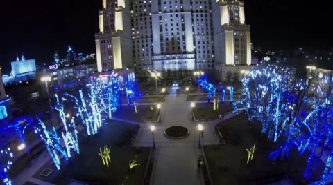 Small square with trees adorned by garlands near building Stock Footage 40181673