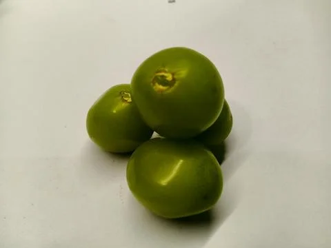 Small stack of fresh green cherry tomatoes on a white background Stock Photos