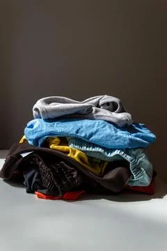 A small stack of old clothes for recycling on a dark background Stock Photos