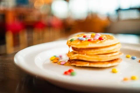 Small Stack of Pancakes with Dripping Honey and Chocolate Lentils on Top Stock Photos