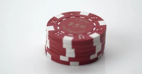 A small stack of red and white poker chips on a white surface Stock Photos