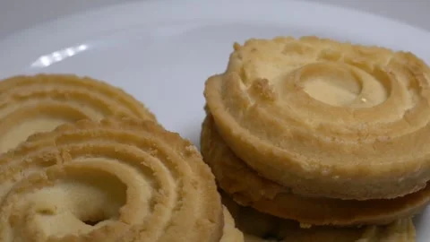 A small stack of round butter cookies with a spiral pattern rotates slowly .. Stock Footage 328485567