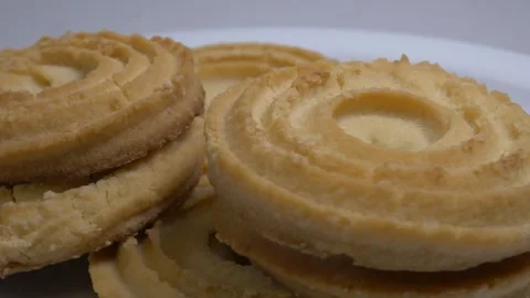 A small stack of round butter cookies with a spiral pattern rotates slowly .. Stock Footage 328485846