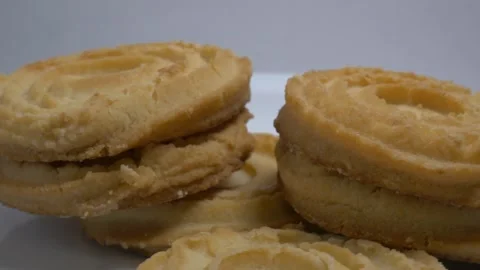 A small stack of round butter cookies with a spiral pattern rotates slowly .. Stock Footage 328485891