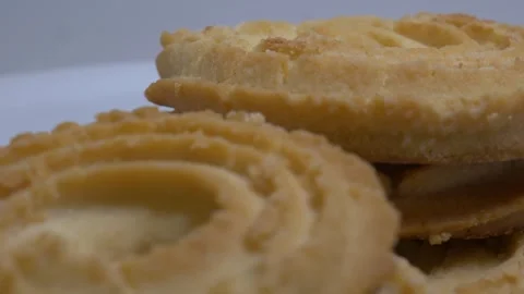 A small stack of round butter cookies with a spiral pattern rotates slowly .. Stock Footage 328485969