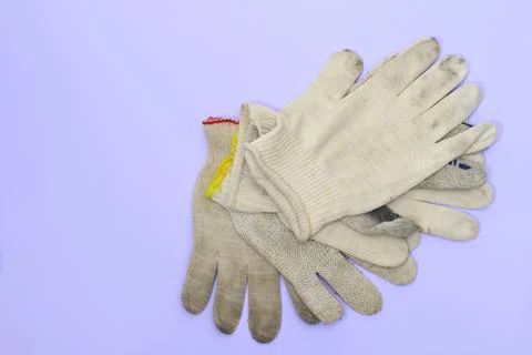 A small stack of simple cloth gloves for manual labor on a purple-blue back.. Stock Photos