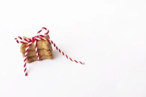 Small stack of three brown dog biscuits tied in red and white string Stock Photos