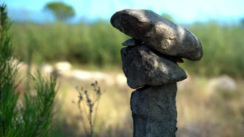 Small standing stone pile with dancing shadow - Zen - Portugal - 4K Stock Footage 159366187