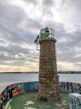 Small stone bricks lighthouse at the entrance to Torrevieja port Foto stock