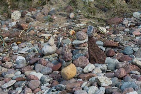 Small stone cairns on a multi colored pebble beach Stock Photos