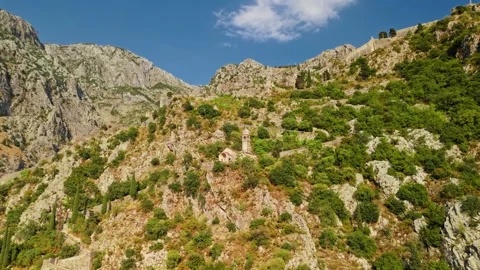 Small Stone Chapel on a Rocky Mountain Slope Aerial Track Stock Footage 345529626