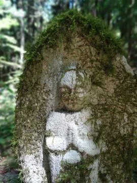Small stone Jizo statue surrounded by green on the Nakasendo Road hike Stock-Fotos