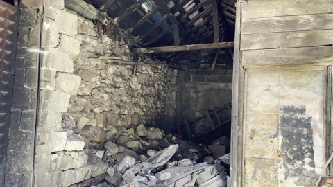 A small stone-walled hut with collapsed wooden roof Stock Footage 246249216