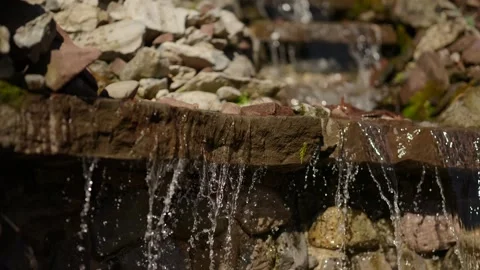 Small stone waterfall cascading over natural rocks Stock Footage 346298851