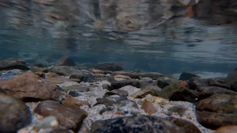 Small stones and sand particles under clear and clean water Stock Footage 171532922