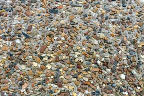 Small stones form a pattern on the concrete surface Foto stock