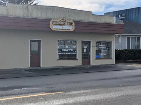 Small storefront “Crescent Cabinets” sits closed with barred windows Stock Photos