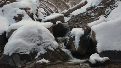 Small stream and snow covered boulders Stock Footage 152001588