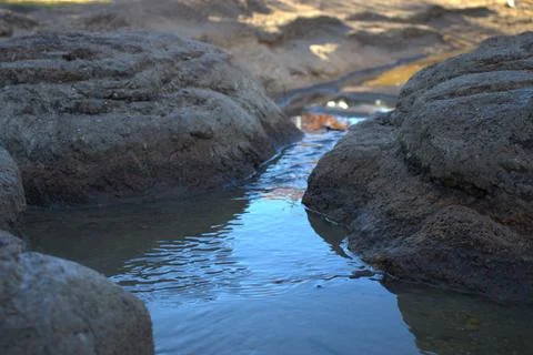 Small Stream Flowing Between Rocks Foto stock