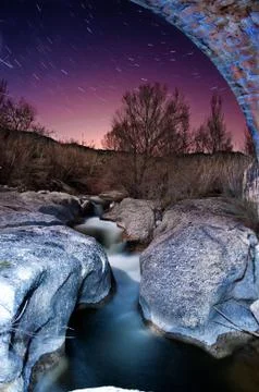 A small stream flowing between stones Stock Photos