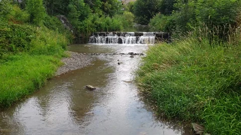 Small Stream Flowing Over Low Stone Weir - Overcast Nature Scene Stock Footage 340051411
