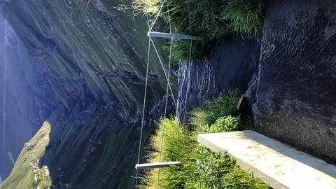 A small stream flows into a mountain gorge, in the middle of a mountain gorge Stock Footage 254510863