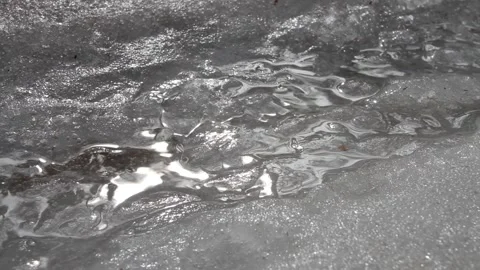 A small stream flows through the melting snow Stock Footage 130229817