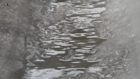 Small stream flows through the wet snow Stock Footage 134232797